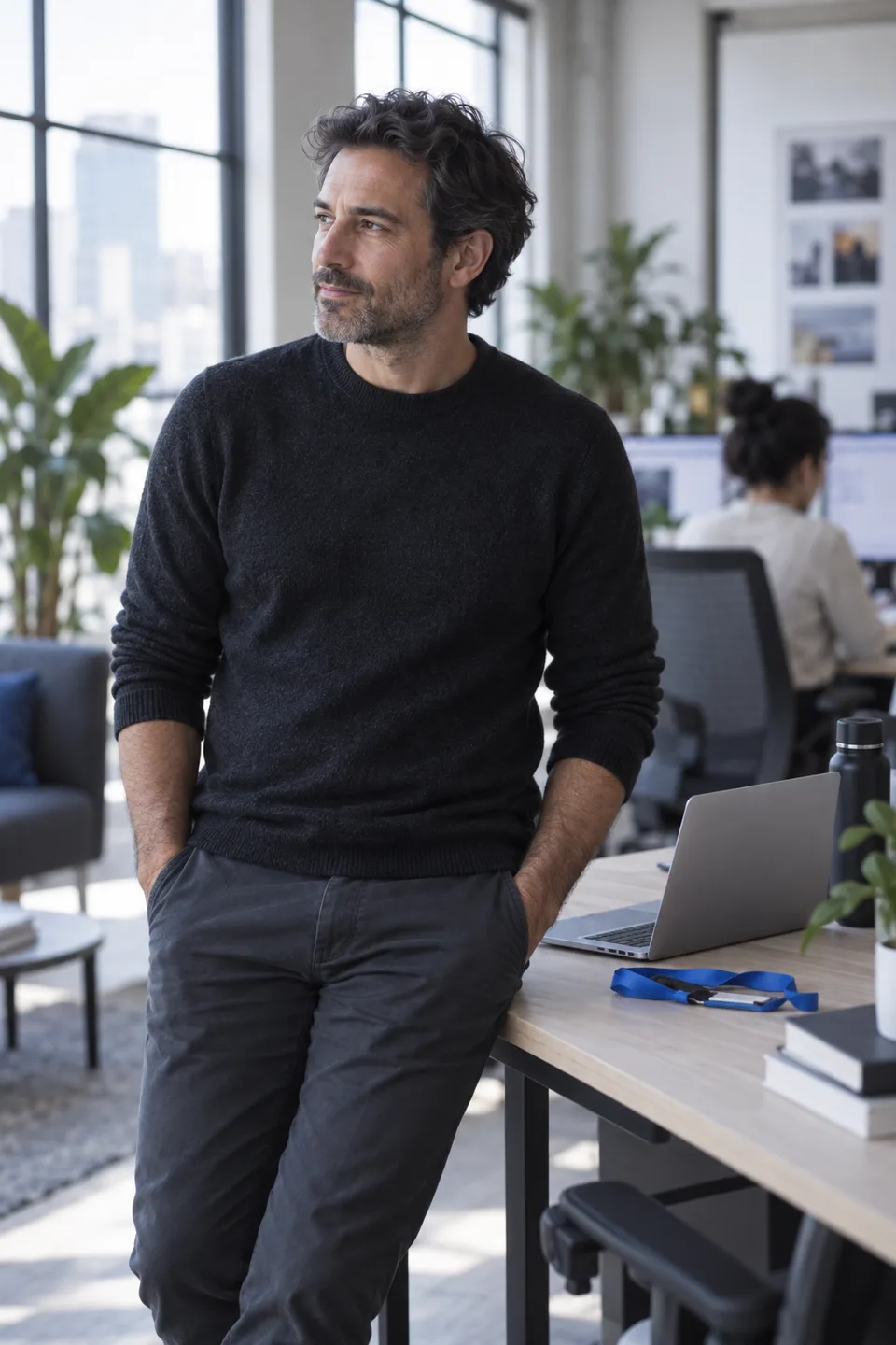 A founder leaning against a desk in a bright studio office